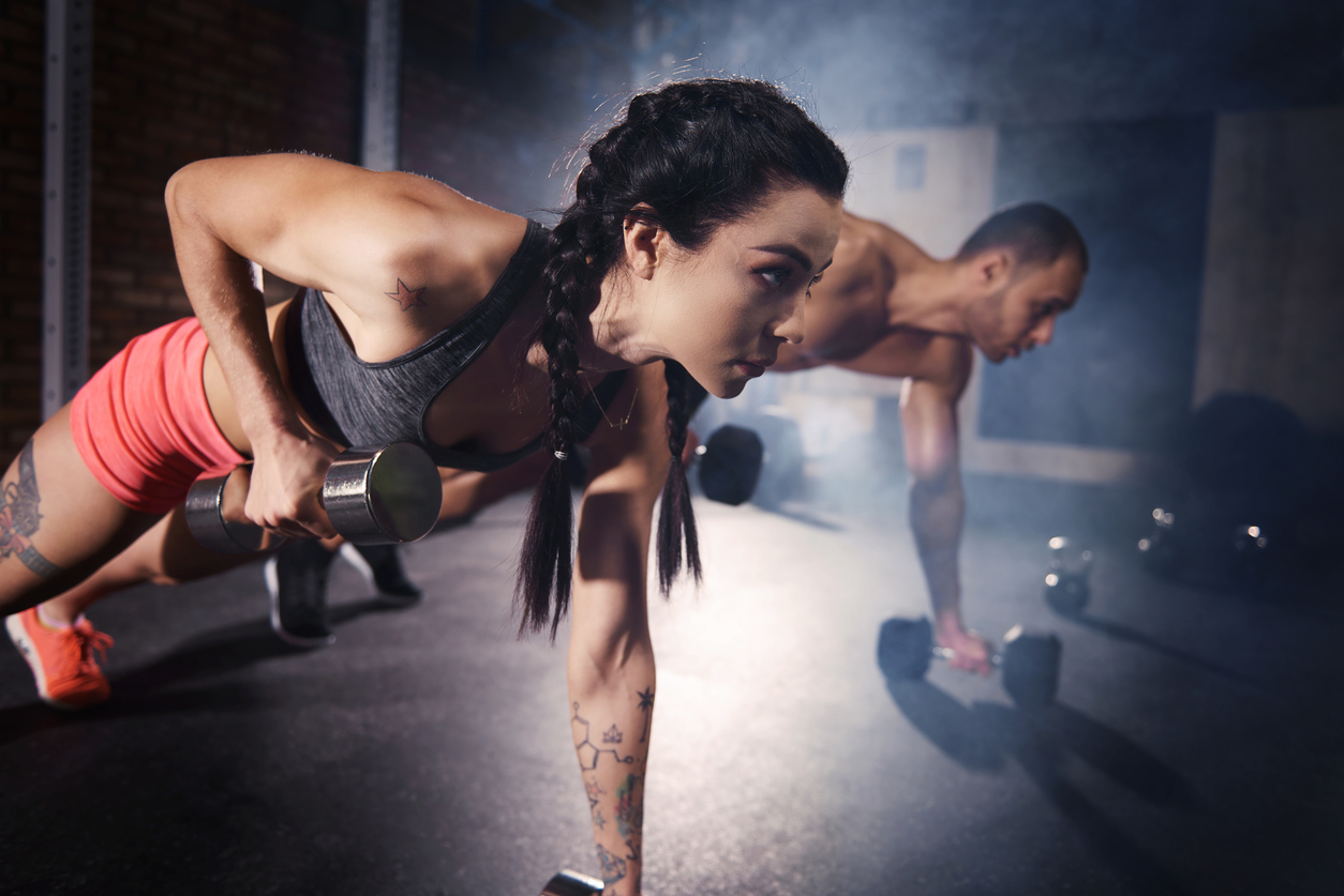 Confident couple working out with dumbbell